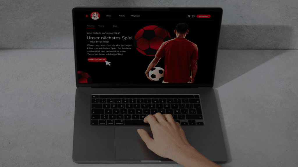 Laptop mit geöffneter Landingpage des Fußballvereins ‚Fortuna West‘ – Hand über Tastatur, Anzeige des nächsten Derby-Spiels sichtbar.